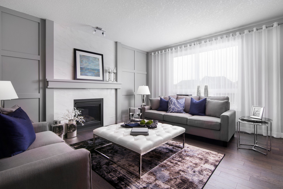 This is an example of a classic formal living room in Calgary with grey walls, dark hardwood flooring, a standard fireplace and no tv.