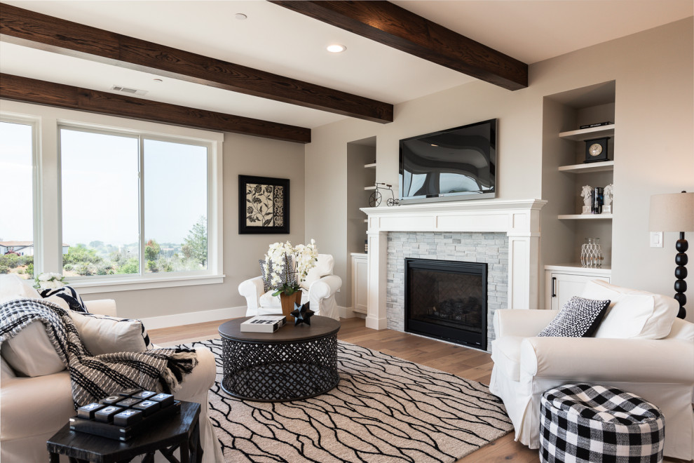 Living room - transitional medium tone wood floor and brown floor living room idea in San Francisco with beige walls, a standard fireplace and a wall-mounted tv