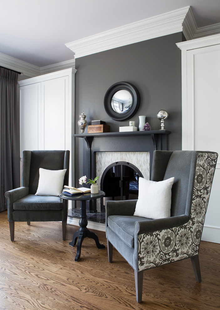 Inspiration pour un salon gris et blanc traditionnel avec un mur gris, un sol en bois brun et une cheminée standard.