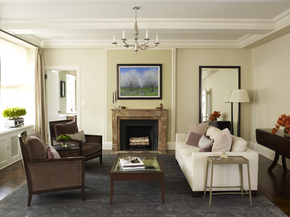 Mittelgroßes Klassisches Wohnzimmer mit beiger Wandfarbe, Kamin, dunklem Holzboden, Kaminumrandung aus Stein und braunem Boden in New York