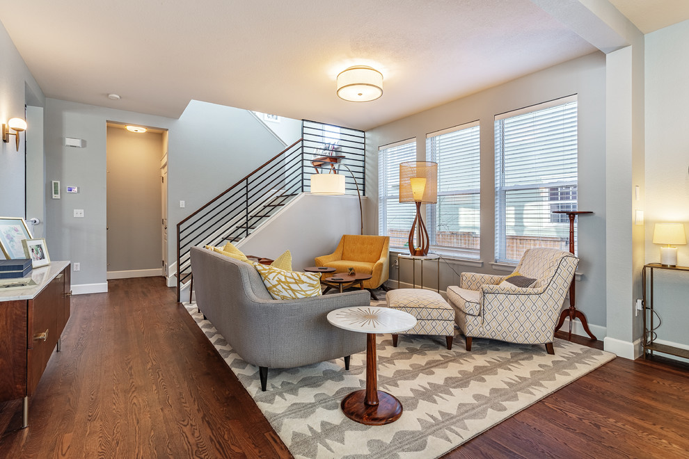 Immagine di un soggiorno chic aperto con pareti grigie, pavimento in legno massello medio e pavimento marrone