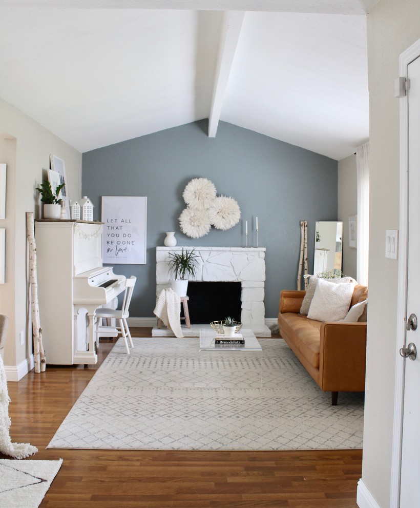 Klassisches Wohnzimmer mit blauer Wandfarbe, braunem Holzboden, Kamin, Kaminumrandung aus Stein und braunem Boden in Sacramento