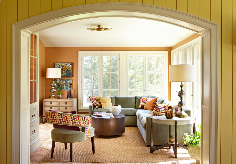 This is an example of a traditional enclosed living room in Other with orange walls.