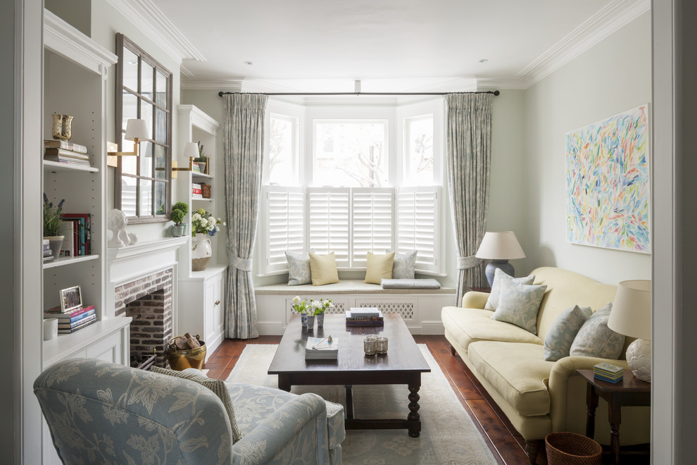 Mittelgroßes, Abgetrenntes, Fernseherloses Klassisches Wohnzimmer mit Kamin, Kaminumrandung aus Backstein, grüner Wandfarbe und braunem Holzboden in London