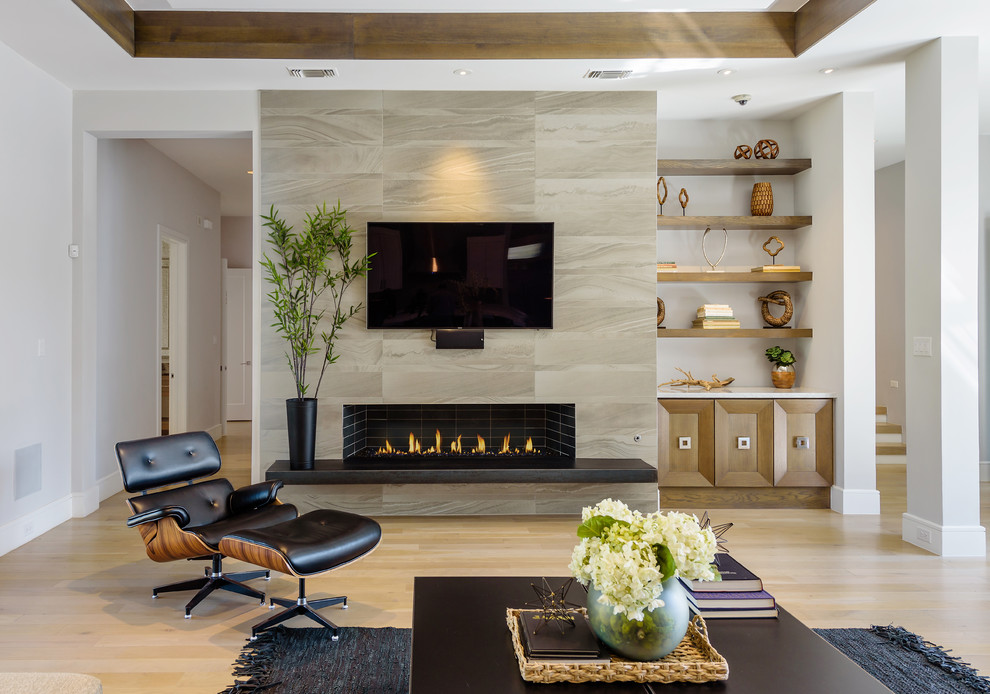 Klassisches Wohnzimmer mit weißer Wandfarbe, hellem Holzboden, Gaskamin, Kaminumrandung aus Backstein, TV-Wand und beigem Boden in Dallas