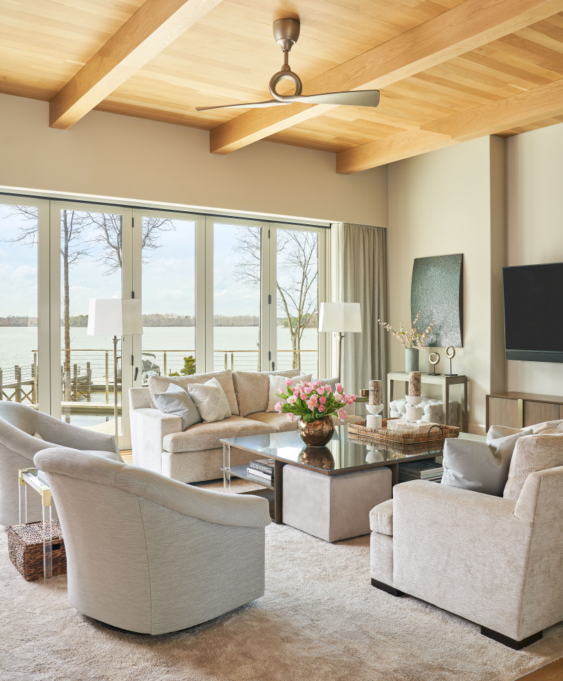 Foto di un soggiorno classico aperto con pareti beige, pavimento in legno massello medio, TV a parete, pavimento marrone e travi a vista