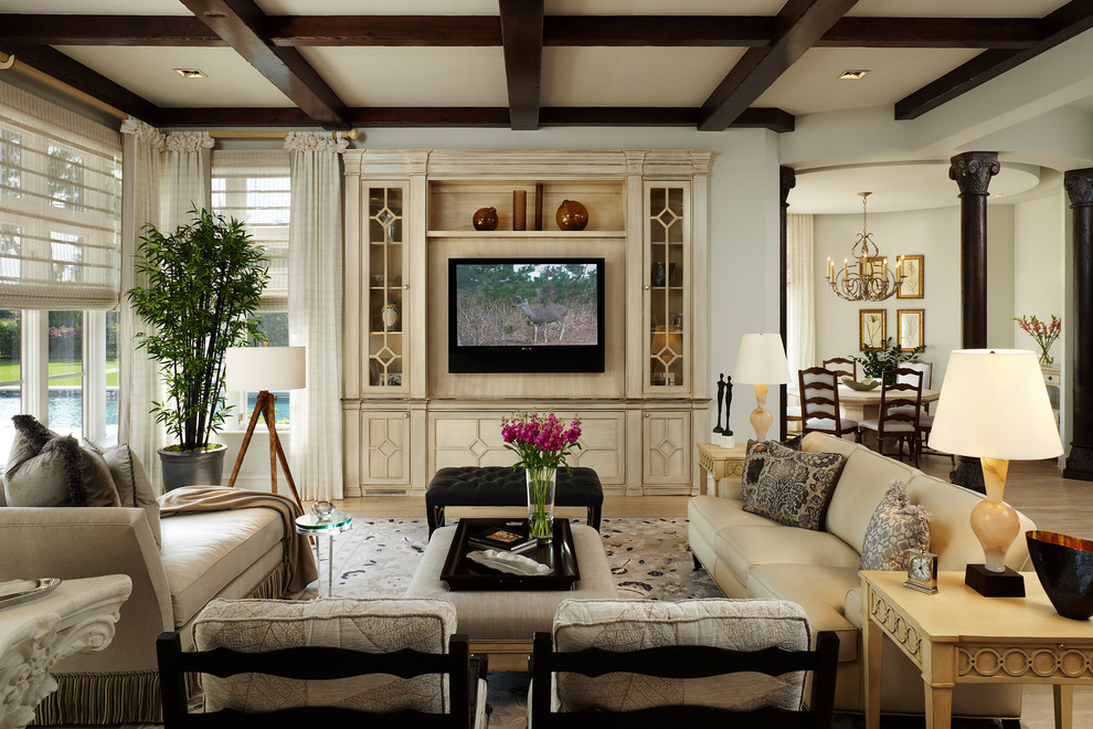 Diseño de salón para visitas abierto tradicional renovado grande sin chimenea con paredes beige, suelo de madera clara, televisor colgado en la pared y suelo beige