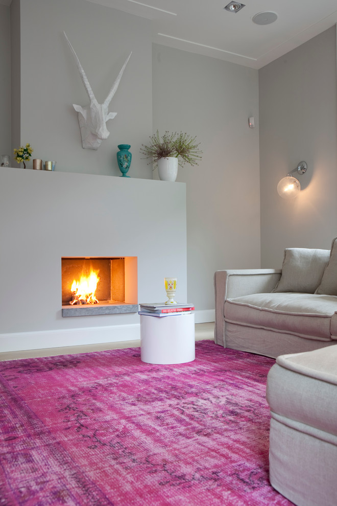 Cette image montre un salon gris et rose traditionnel avec un mur gris, une cheminée standard et aucun téléviseur.