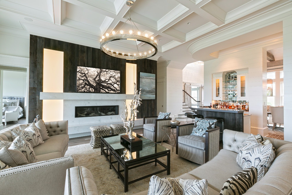 Offenes Klassisches Wohnzimmer mit Hausbar, weißer Wandfarbe, braunem Holzboden, Gaskamin, Kaminumrandung aus Stein und braunem Boden in Charleston