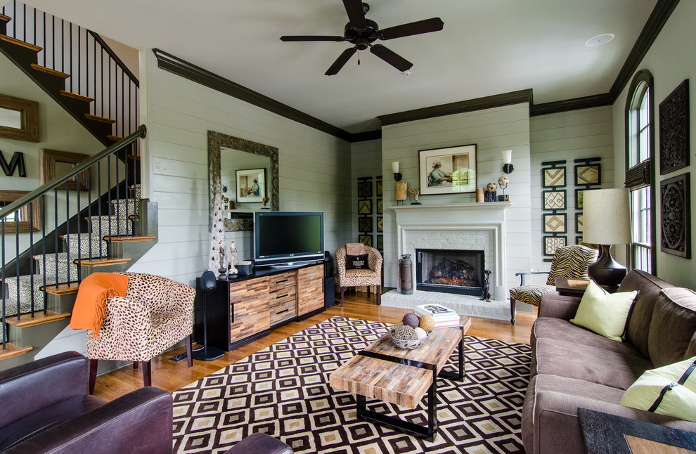 This is an example of a traditional living room in Atlanta with medium hardwood flooring and a freestanding tv.