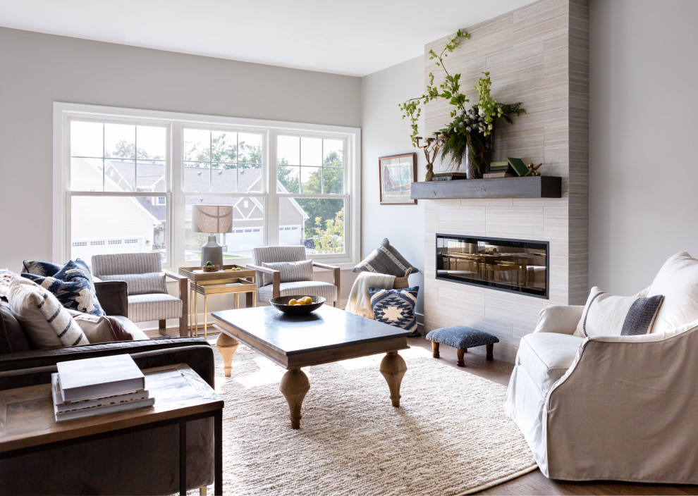 Inspiration for a transitional open concept medium tone wood floor and beige floor living room remodel in Detroit with gray walls, a ribbon fireplace and a tile fireplace