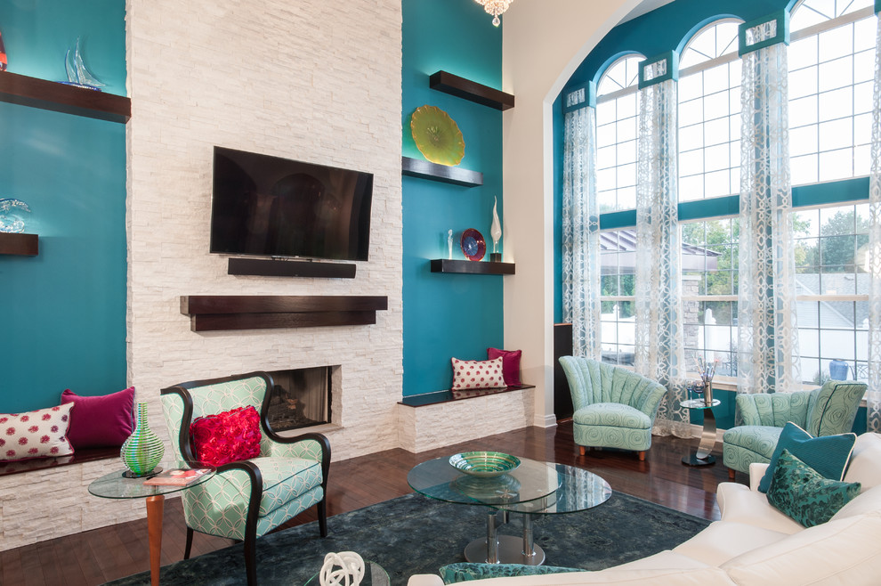 Example of a large transitional formal and open concept dark wood floor living room design in St Louis with blue walls, a standard fireplace, a stone fireplace and a wall-mounted tv