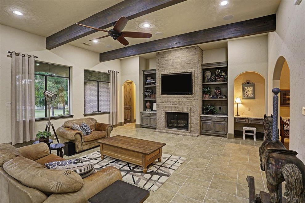 This is an example of an expansive traditional formal open plan living room in Houston with white walls, ceramic flooring, a standard fireplace, a brick fireplace surround, a wall mounted tv and beige floors.
