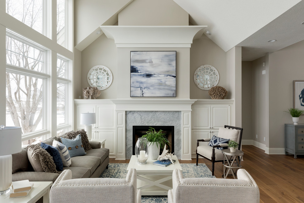Repräsentatives, Offenes Klassisches Wohnzimmer mit grauer Wandfarbe, braunem Holzboden, Kamin und Kaminumrandung aus Stein in Minneapolis