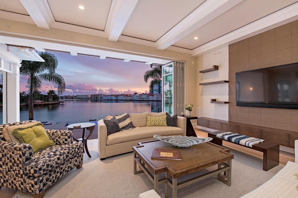 Mittelgroßes, Abgetrenntes Klassisches Wohnzimmer mit beiger Wandfarbe, hellem Holzboden, TV-Wand und beigem Boden in Miami