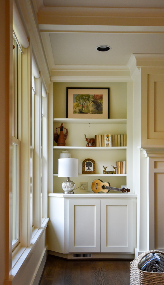 Offenes Klassisches Wohnzimmer mit beiger Wandfarbe, dunklem Holzboden, Kamin, Kaminumrandung aus Stein und braunem Boden in Sonstige