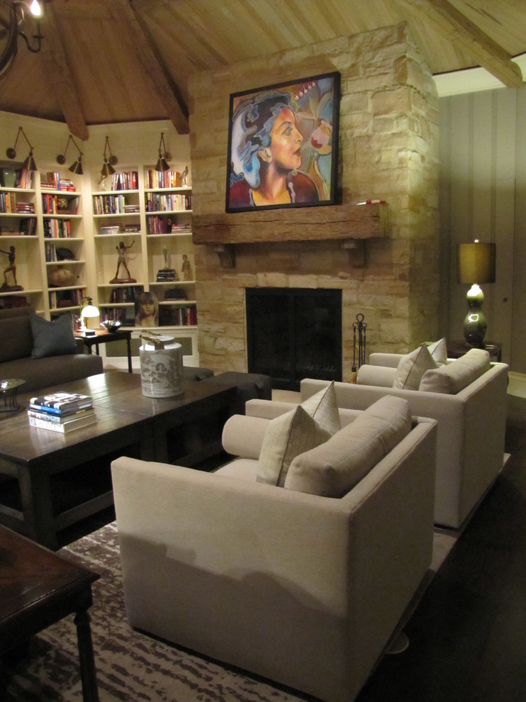 Immagine di un grande soggiorno tradizionale aperto con libreria, pareti grigie, parquet scuro, camino classico, cornice del camino in pietra e nessuna TV