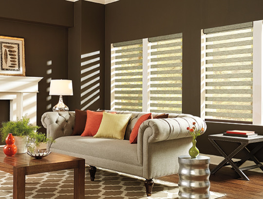 Cette image montre un salon design de taille moyenne et fermé avec un mur marron, un sol en bois brun, une cheminée standard, un manteau de cheminée en plâtre, aucun téléviseur et un sol marron.