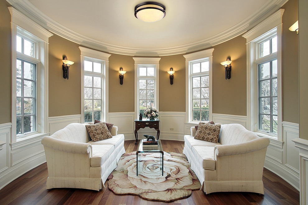 Idée de décoration pour un salon tradition de taille moyenne et fermé avec un mur beige et un sol en bois brun.