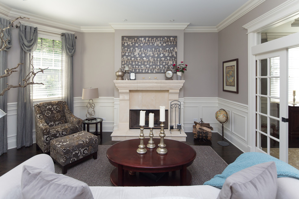 Пример оригинального дизайна: парадная гостиная комната среднего размера в классическом стиле с серыми стенами, темным паркетным полом, стандартным камином и фасадом камина из камня