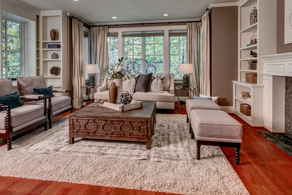 Photo of a medium sized classic formal enclosed living room in Seattle with brown walls, medium hardwood flooring, a standard fireplace, a wooden fireplace surround and red floors.