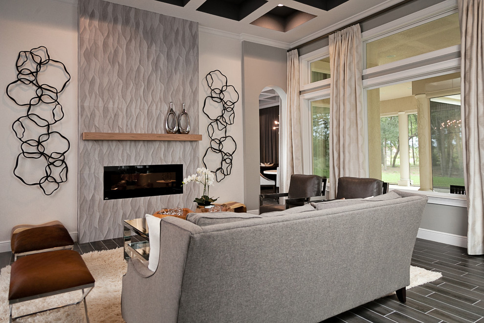 Идея дизайна: большая парадная, открытая гостиная комната в стиле неоклассика (современная классика) с серыми стенами, полом из керамогранита, горизонтальным камином, фасадом камина из плитки и серым полом без телевизора
