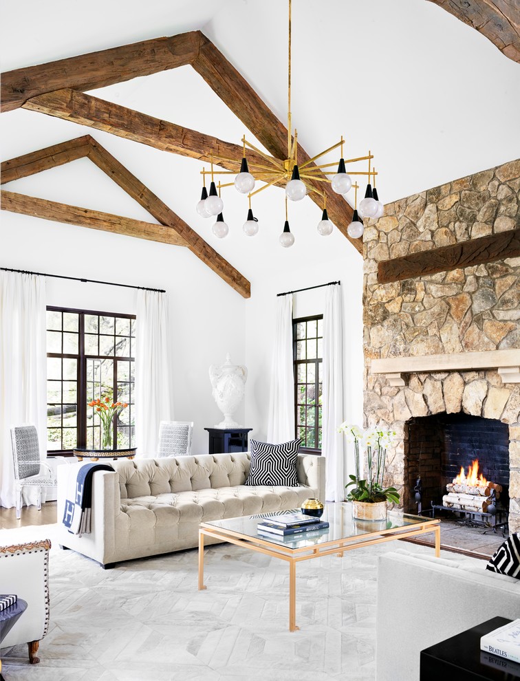 Classic formal open plan living room in Austin with white walls, a standard fireplace and a stone fireplace surround.