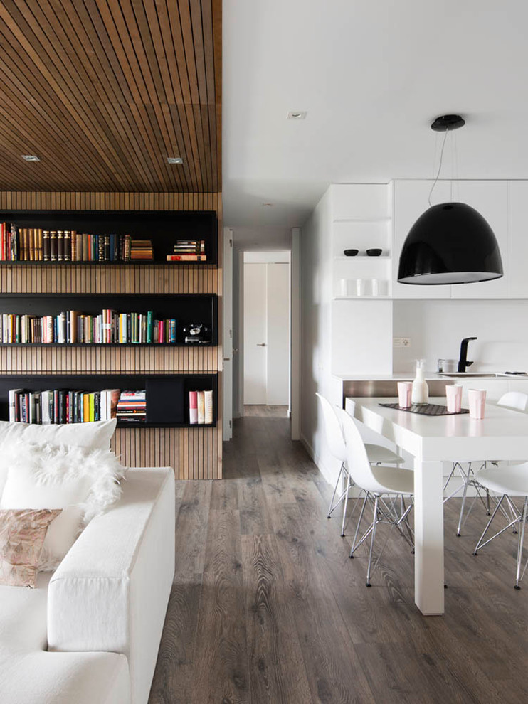 Exemple d'un grand salon tendance ouvert avec une bibliothèque ou un coin lecture, un mur blanc et un sol en bois brun.