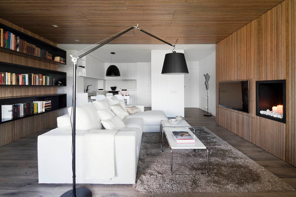 Foto di un grande soggiorno minimal aperto con libreria, pareti marroni, parquet scuro e TV a parete
