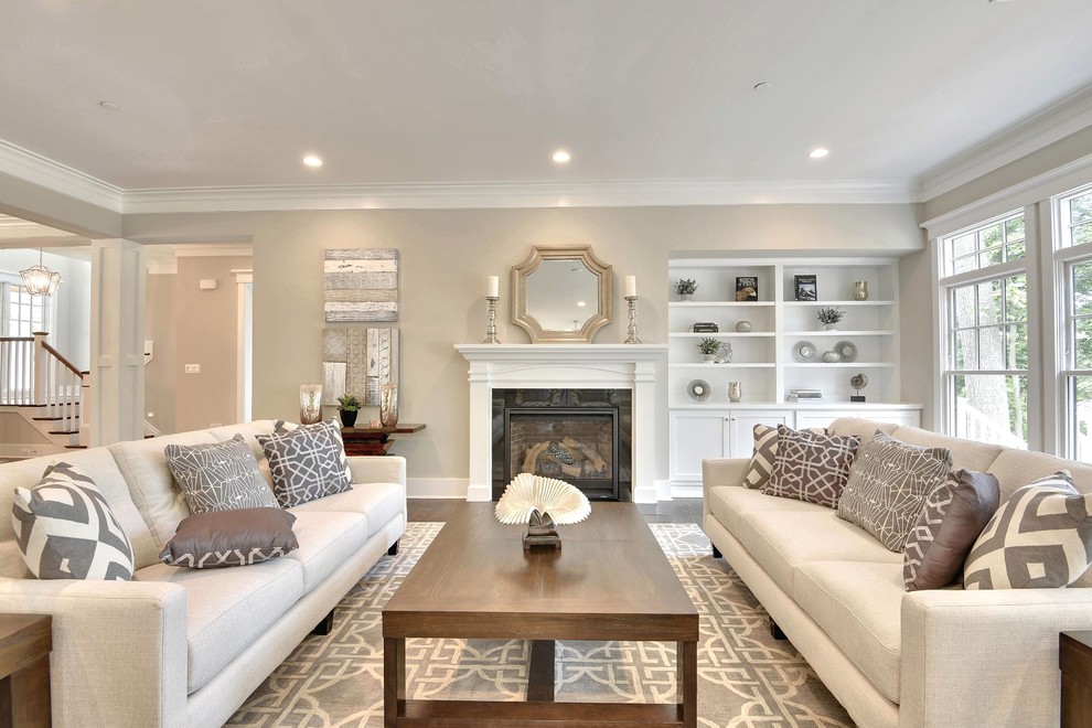 This is an example of a large classic formal open plan living room in DC Metro with beige walls, medium hardwood flooring, a standard fireplace, a wooden fireplace surround, no tv and brown floors.