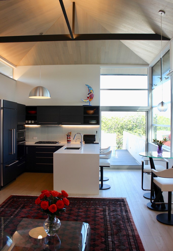 Foto de salón tipo loft moderno pequeño con paredes blancas, suelo de madera clara, televisor retractable y suelo beige
