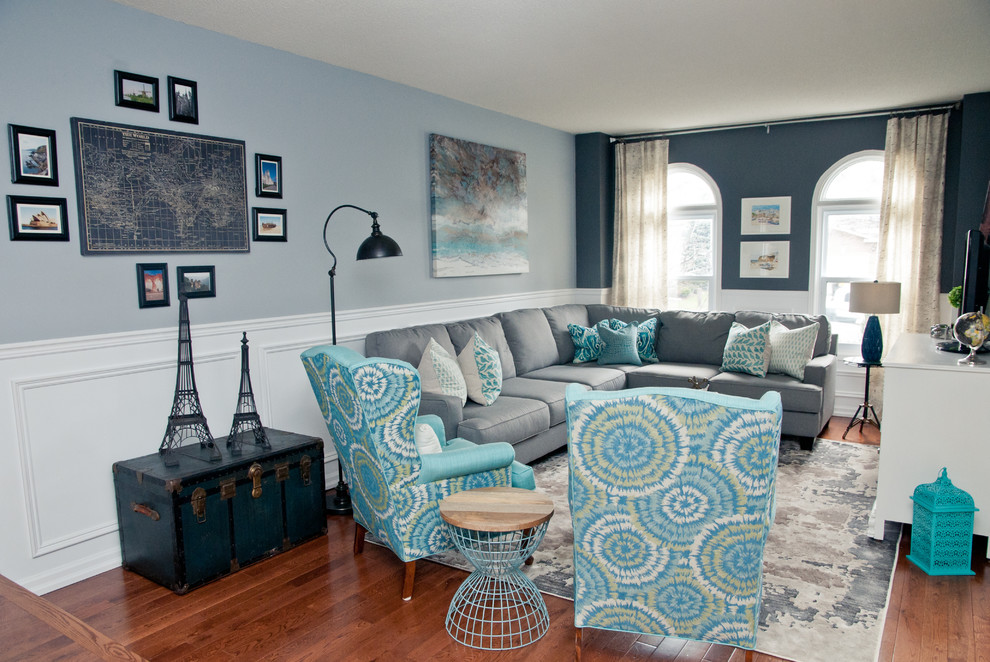 Design ideas for a classic grey and teal open plan living room in Toronto with grey walls, medium hardwood flooring and a freestanding tv.