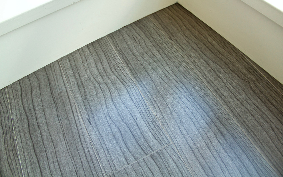 Modern inredning av ett mellanstort allrum med öppen planlösning, med beige väggar, ljust trägolv och grått golv