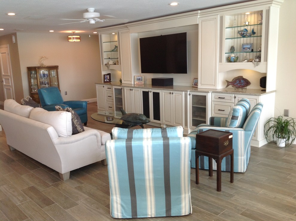 Offenes Maritimes Wohnzimmer mit beiger Wandfarbe, Multimediawand und Porzellan-Bodenfliesen in Tampa