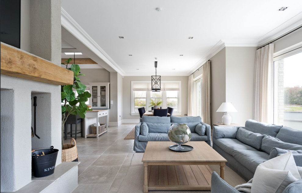 Photo of a large beach style enclosed living room in Dublin with beige walls, limestone flooring, a corner fireplace, a stone fireplace surround, a wall mounted tv, grey floors and exposed beams.