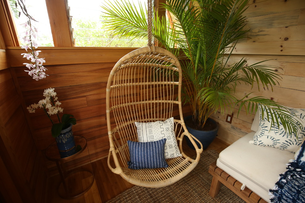 Ispirazione per un piccolo soggiorno tropicale chiuso con pareti beige, pavimento in legno massello medio, nessun camino, nessuna TV e pavimento marrone