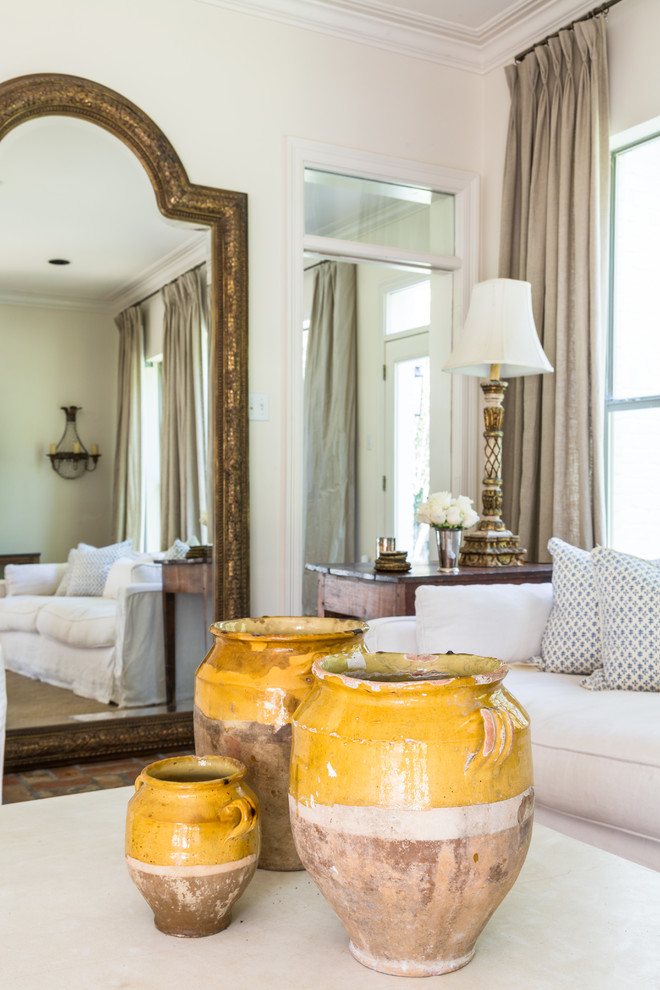 Immagine di un grande soggiorno chic aperto con pareti bianche, pavimento in mattoni e pavimento marrone