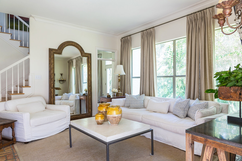 На фото: большая открытая гостиная комната в классическом стиле с белыми стенами, кирпичным полом и коричневым полом