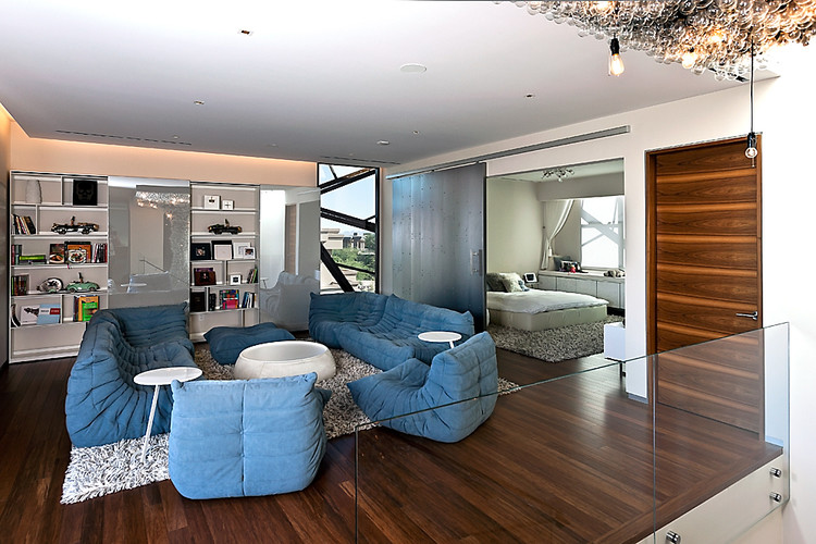 Mittelgroßes, Fernseherloses Modernes Wohnzimmer ohne Kamin, im Loft-Stil mit weißer Wandfarbe und dunklem Holzboden in New York