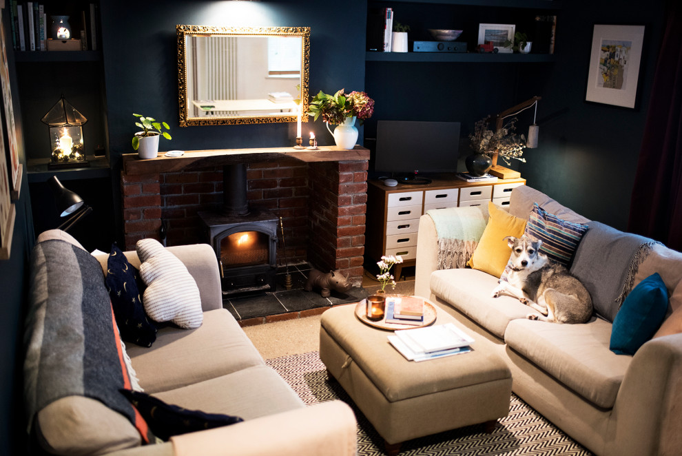 Diseño de salón para visitas cerrado tradicional pequeño con paredes azules, moqueta, estufa de leña, marco de chimenea de ladrillo, televisor independiente y suelo beige