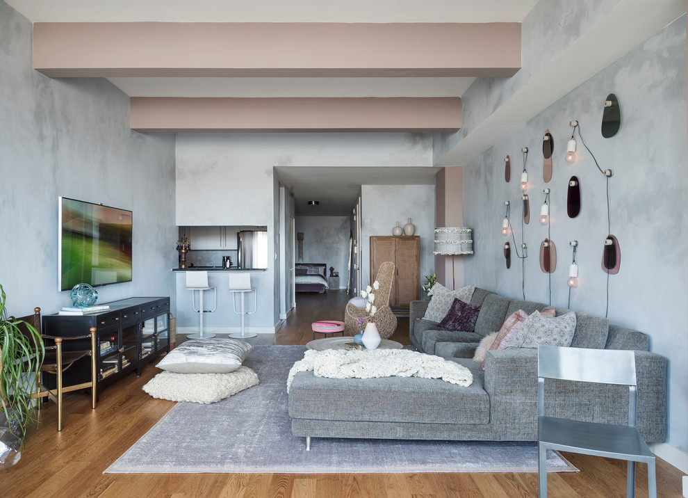 Свежая идея для дизайна: двухуровневая гостиная комната среднего размера в стиле фьюжн с серыми стенами, паркетным полом среднего тона и телевизором на стене без камина - отличное фото интерьера