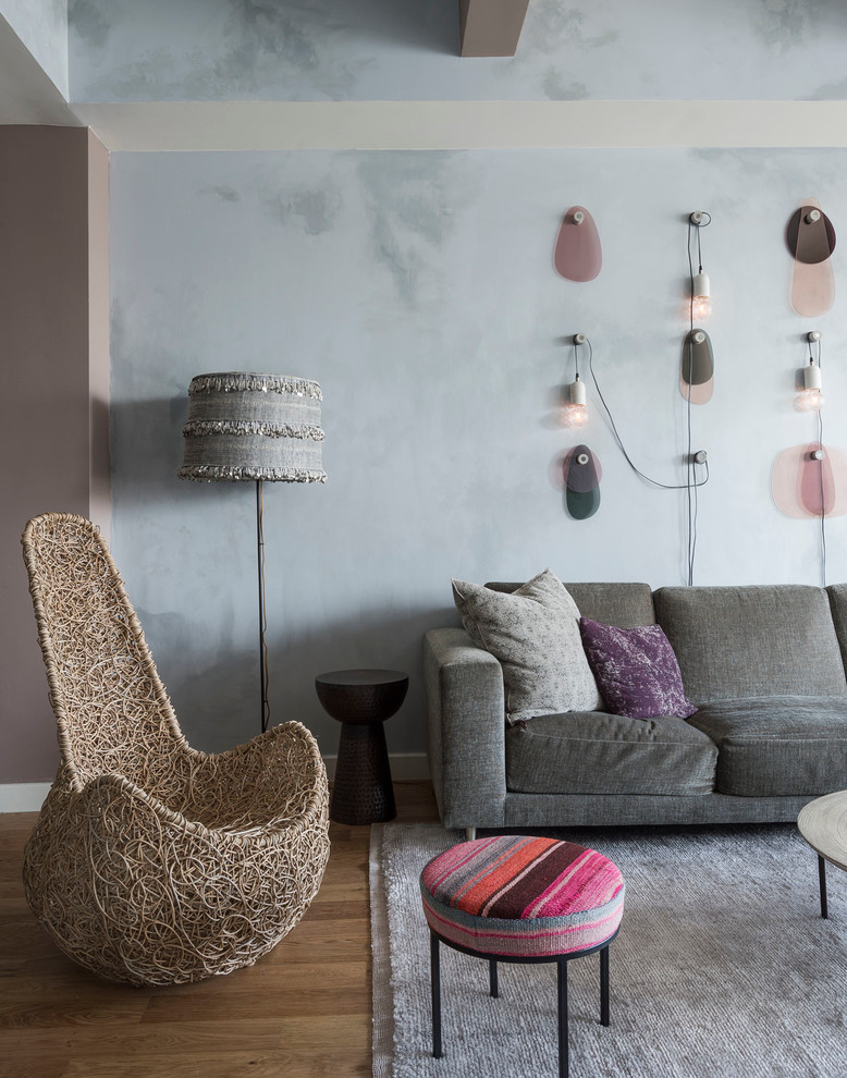 Réalisation d'un salon mansardé ou avec mezzanine bohème de taille moyenne avec un mur gris, un sol en bois brun, aucune cheminée et un téléviseur fixé au mur.