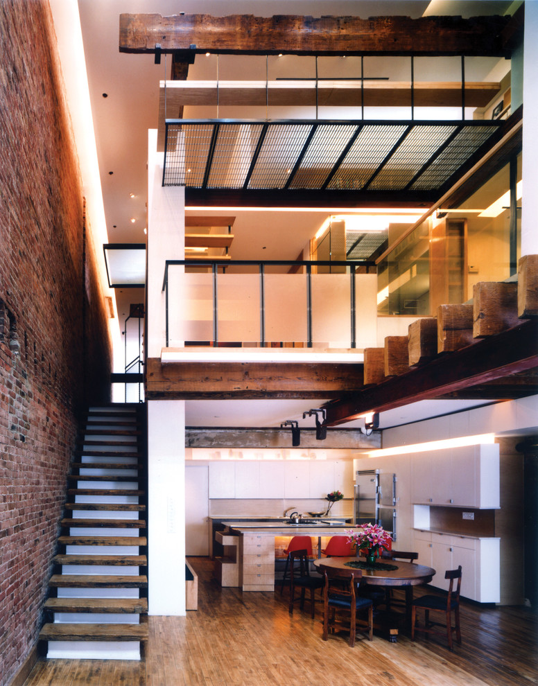 Mittelgroßes, Repräsentatives, Fernseherloses Modernes Wohnzimmer ohne Kamin, im Loft-Stil mit weißer Wandfarbe und hellem Holzboden in New York