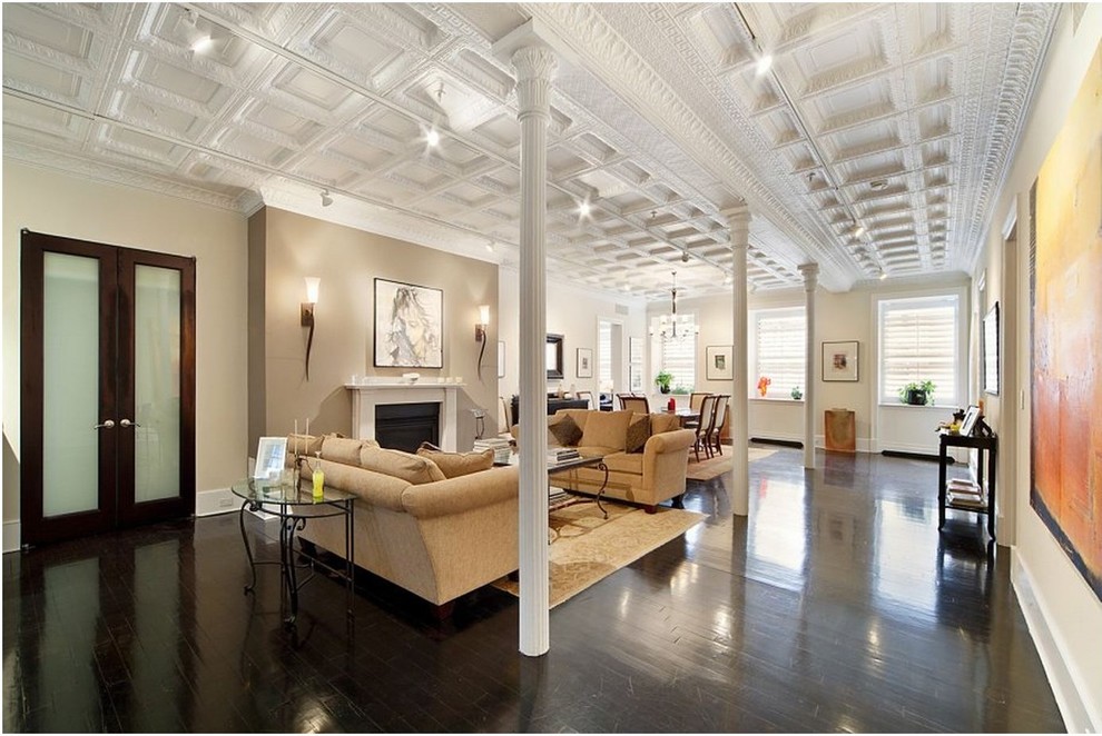 Idée de décoration pour un grand salon tradition ouvert avec une salle de réception, un mur beige, parquet foncé, un poêle à bois et un manteau de cheminée en plâtre.