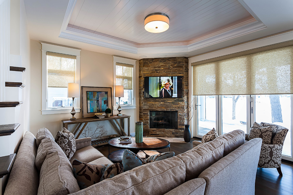 This is an example of a medium sized classic formal open plan living room in Grand Rapids with beige walls, medium hardwood flooring, a corner fireplace, a stone fireplace surround and a wall mounted tv.
