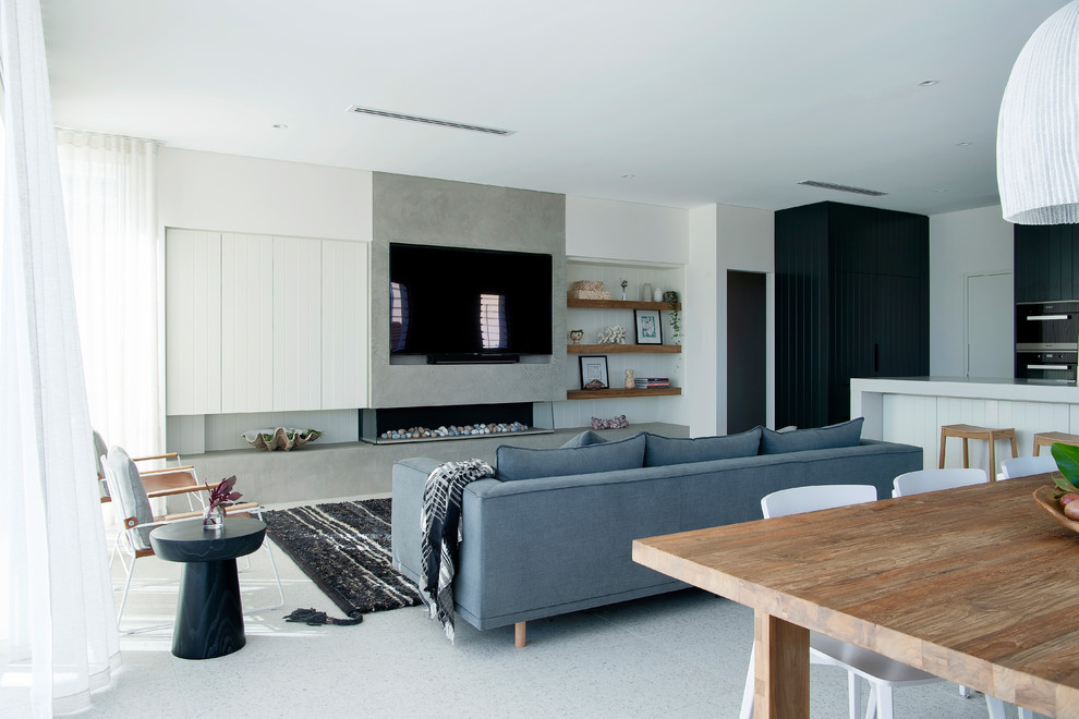 Mittelgroßes, Offenes Maritimes Wohnzimmer mit Porzellan-Bodenfliesen, Gaskamin, Kaminumrandung aus Beton, TV-Wand, weißer Wandfarbe und weißem Boden in Perth