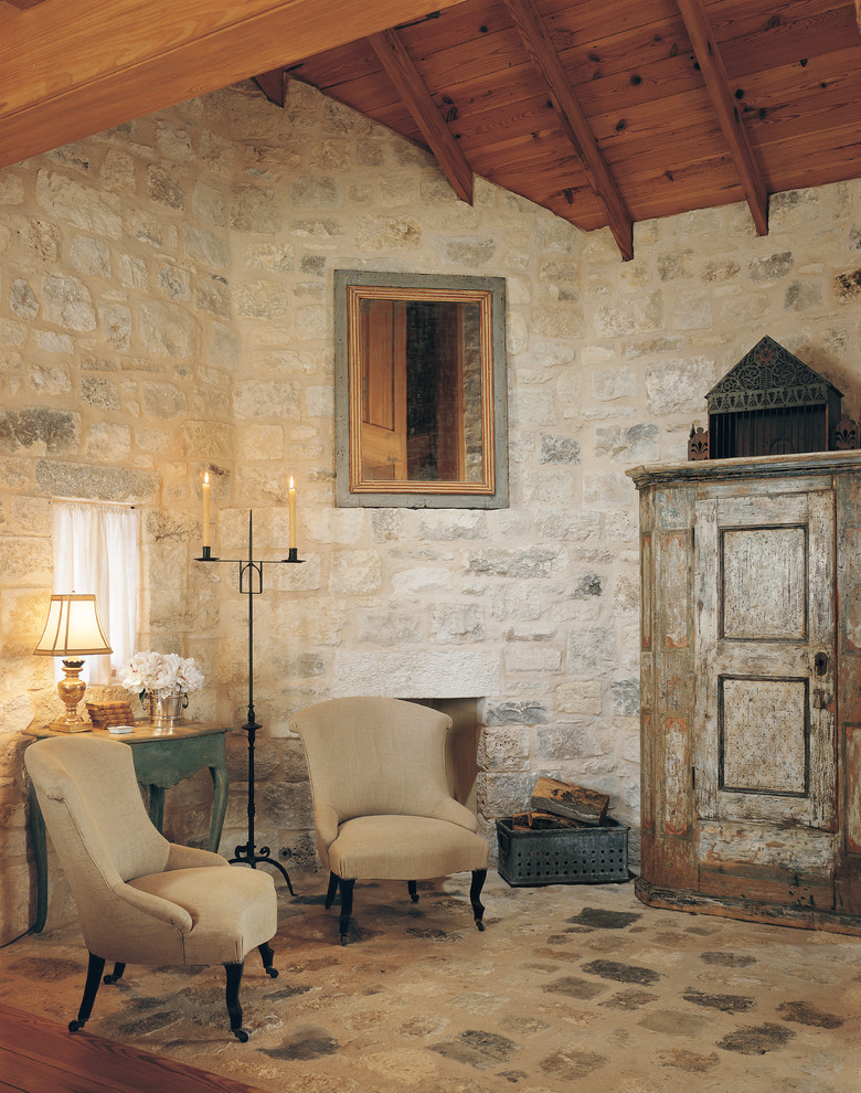 Aménagement d'un salon campagne avec une cheminée standard, un manteau de cheminée en pierre et un mur en pierre.