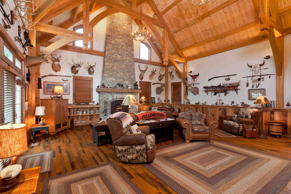 Imagen de salón para visitas cerrado rural grande con paredes blancas, suelo de madera oscura, todas las chimeneas, marco de chimenea de piedra y televisor retractable