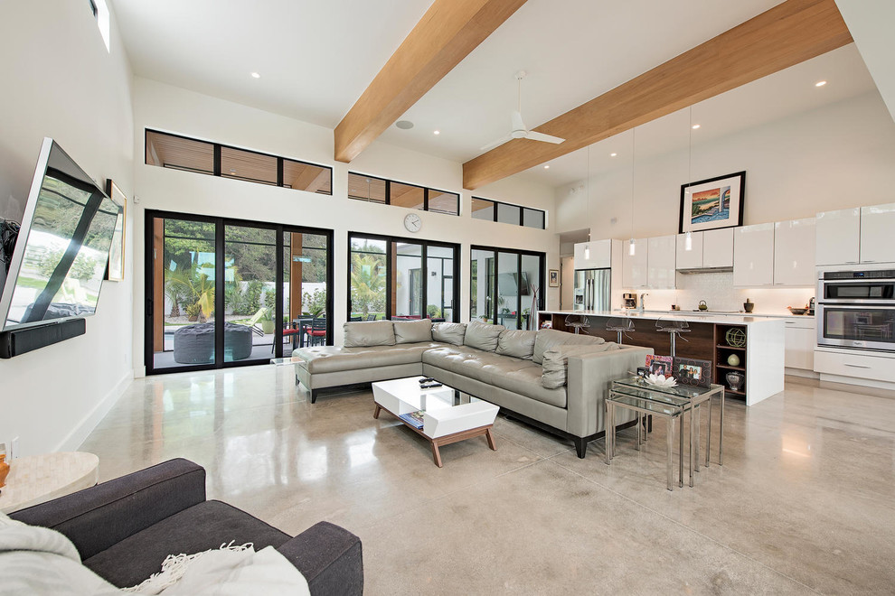 Mittelgroßes, Offenes Modernes Wohnzimmer mit weißer Wandfarbe und Betonboden in Miami