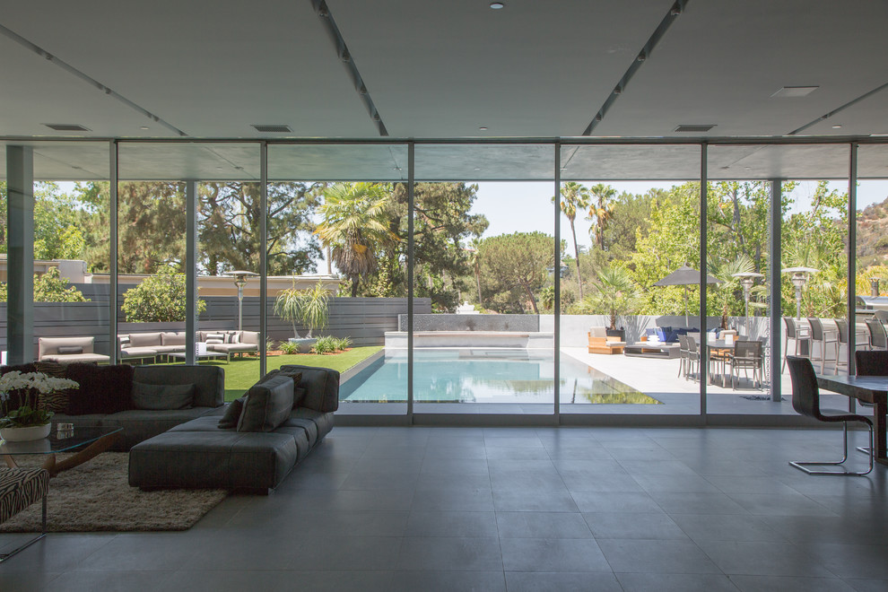 Repräsentatives, Fernseherloses, Offenes Modernes Wohnzimmer ohne Kamin mit weißer Wandfarbe, Betonboden und grauem Boden in Los Angeles